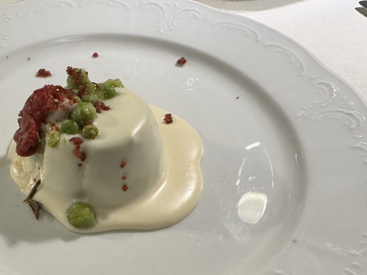 Flan ai piselli freschi, pomodorino confit, polvere di speck e fonduta di Asiago